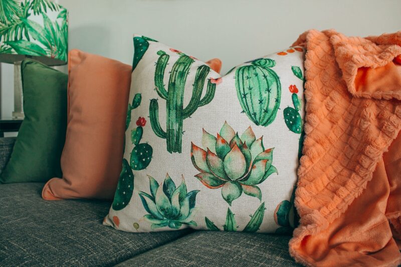 A sofa with three colorful pillows on it. image - A sofa with three colorful pillows on it.
